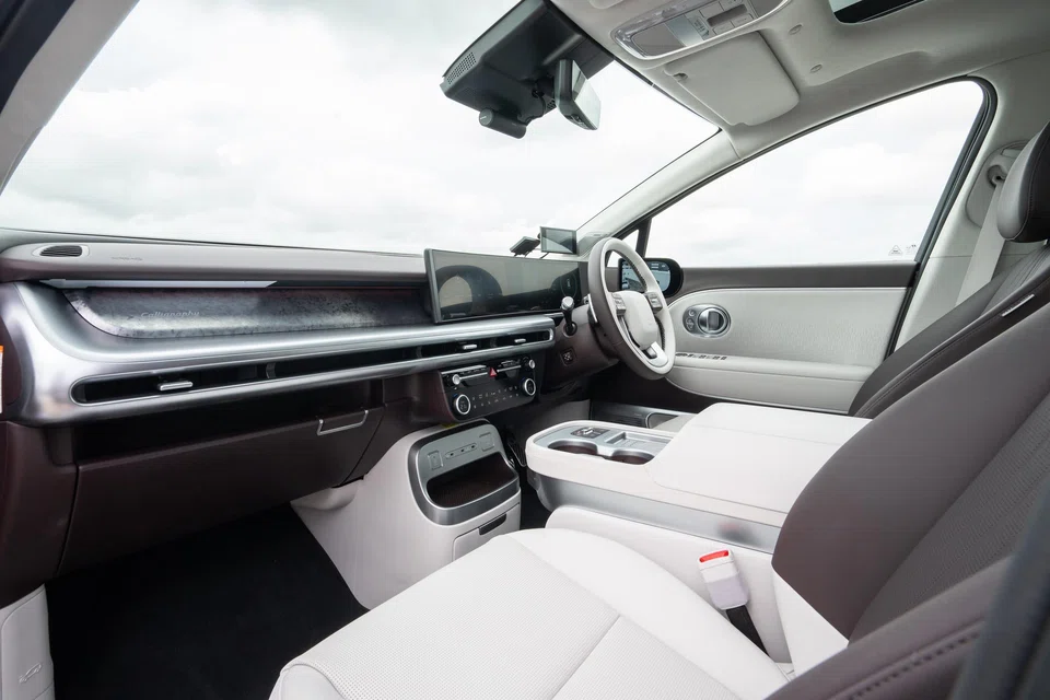 The sliding console can shift rearward to bridge the gap between the front and middle rows.