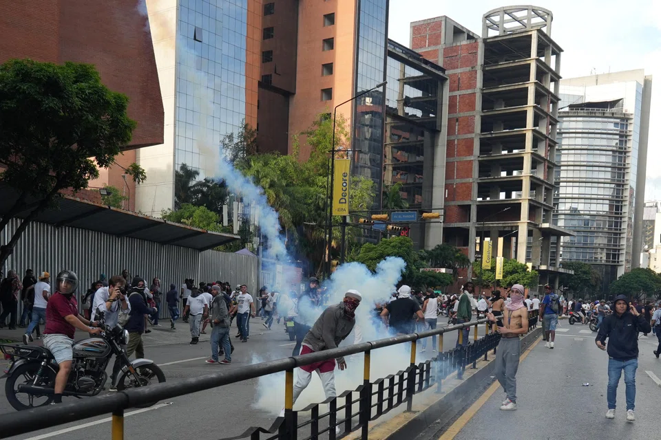 A protester throws back a tear gas canister as Venezuelan opposition supporters protest following the announcement by the National Electoral Council that Venezuela's President Nicolas Maduro won the presidential election, Caracas, Venezuela ,July 29, 2024. 