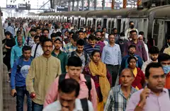 Commuters after disembarking from a suburban train at a railway station in Mumbai, India, January 2023. 