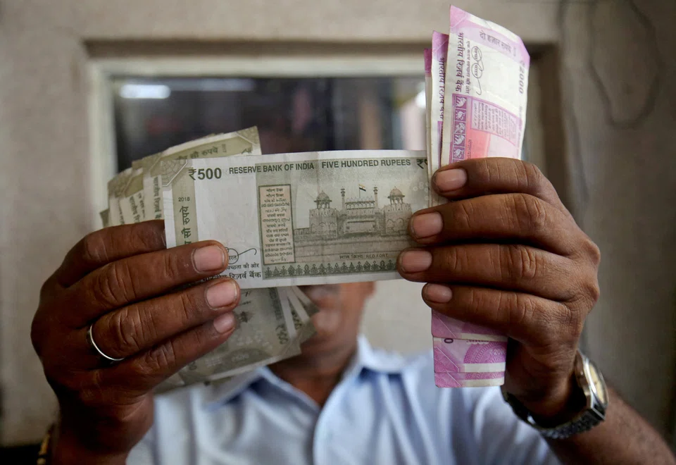 A cashier checks Indian rupee notes inside a room at a fuel station in Ahmedabad, India. Earlier this year, India overtook the UK to become the world's fifth-largest economy.