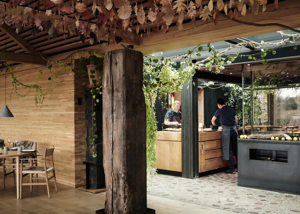 Two chefs cook in an open-air kitchen at Noma in Copenhagen on Dec 2, 2022. A signature of Noma and its cuisine is its luxurious, modern-rustic aesthetic.
