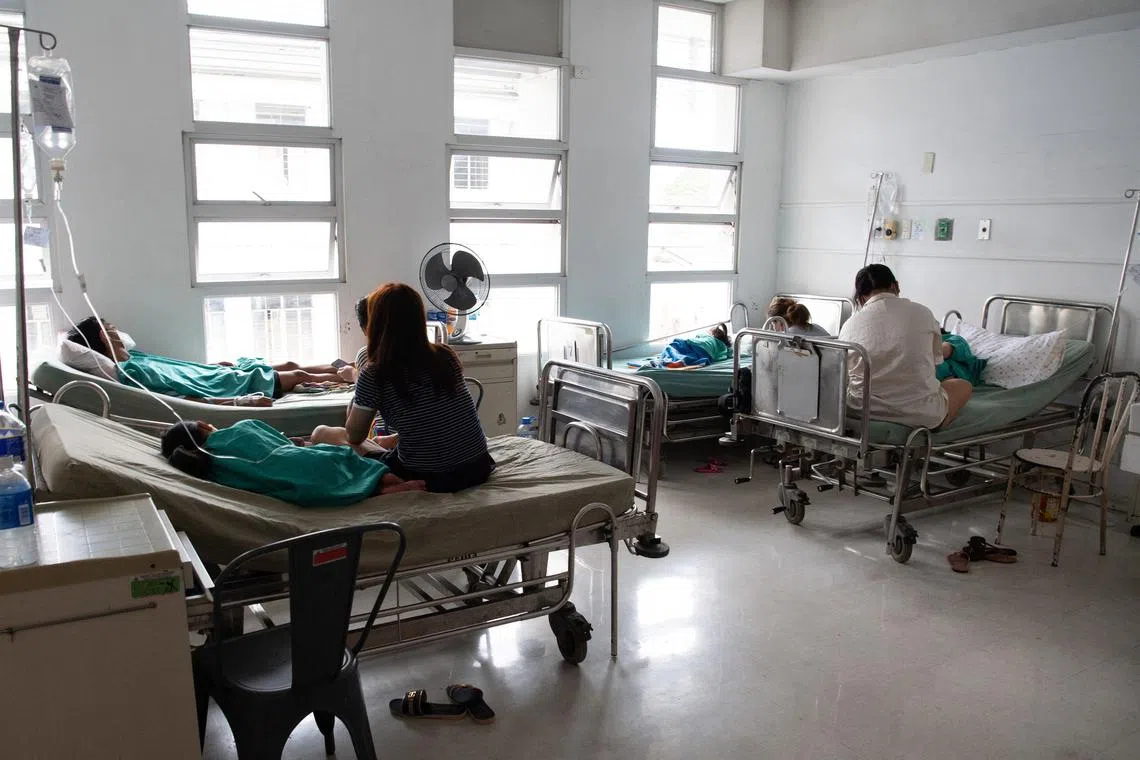 Patients infected with dengue rest at a hospital ward in Manila on February 19, 2025. Residents in a central Manila neighbourhood lined up, amid a national spike in dengue cases to collect a bounty -- one peso for every five mosquitoes, dead or alive. (Photo by Ted ALJIBE / AFP)