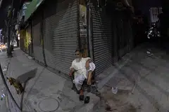 A man sits outside a closed shop on Apr 10 at a market after authorities ordered closures to reduce energy consumption in Karachi.
