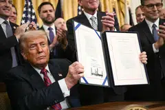 US President Donald Trump displays the GENIUS Act (Guiding and Establishing National Innovation for US Stablecoins Act), which codifies the use of stablecoins -cryptocurrencies pegged to stable assets like the US dollar or US bonds -- after signing it in the White House, Washington, D.C., July 18, 2025. 