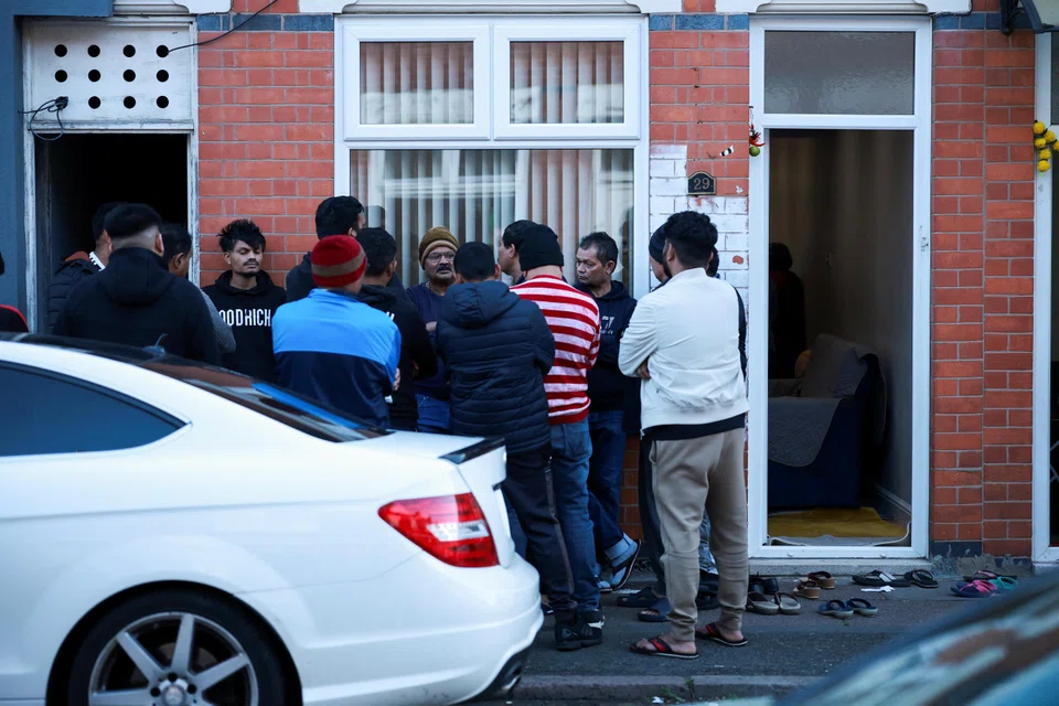 Members of the local community stand outside the family home of Ramesh Viswashkumar, a British survivor of the London-bound Air India aircraft crash near Ahmedabad Airport in India, Leicester, Britain, June 12, 2025.  