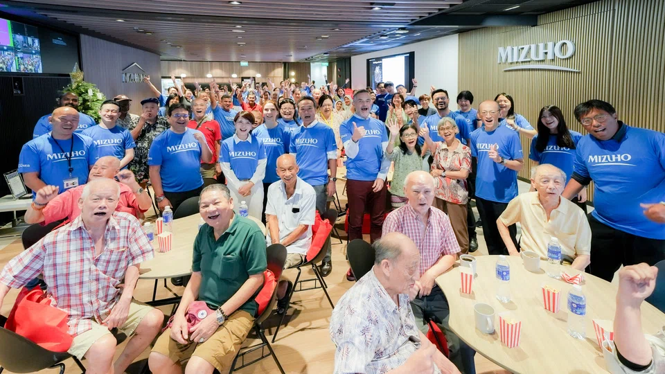 Mizuho Bank Singapore CEO Josephine Lok (fourth from left, in blue) at Mizuho Foundation's festive gathering with seniors from Awwa Senior Community Home.