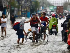 Pedestrians and motorists make their way through the water on a flooded road in Meycauayan, Bulacan, the Philippines in the wake of typhoon Gaemi in July. Asean countries such as the Philippines are among the most vulnerable to climate risks.