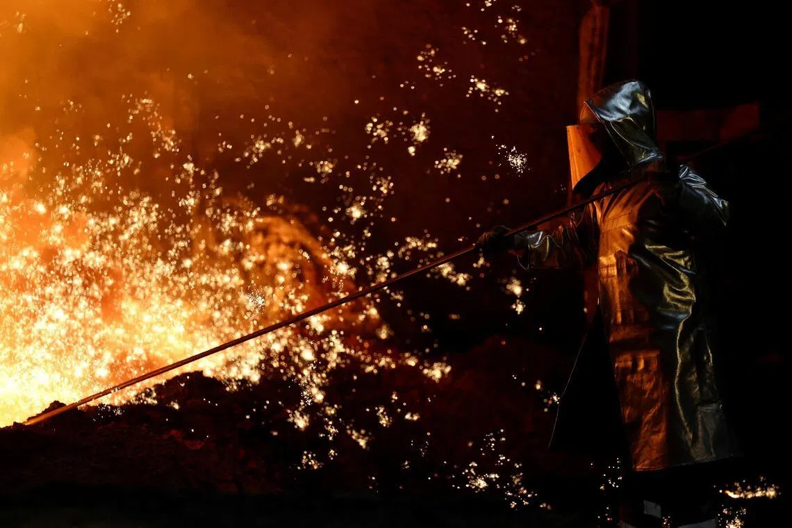 A steel worker stands amid sparks of raw iron coming from a blast furnace at a ThyssenKrupp steel factory in Duisburg, Germany, Nov 5, 2025. 