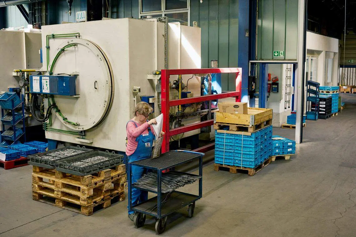A worker stands beside a furnace at Technotherm Heat Treatment Group, which must meet new rules on energy requirements, in Goppingen, Baden-Wurttemberg, Germany, March 14, 2024. Companies in Germany complain that the demands of bureaucracy cost them time and money that would be better spent building their businesses. 
