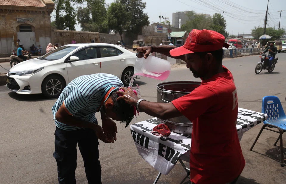 A man puts a wet towel on the head of citizens to avoid heatstroke in Karachi. The Pakistan Meteorological Department (PMD) said that a severe heatwave that has been affecting central and upper Sindh will affect the entire province. 