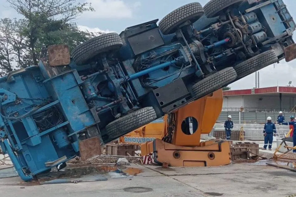 A lorry crane is seen toppled on its left side at an ExxonMobil project site.