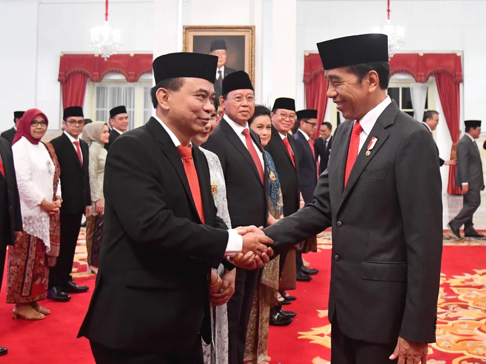 Indonesia's Communications and Information Minister Budi Arie Setiadi (left) shakes hands with President Joko Widodo at the Presidential Palace in Jakarta. His ministry blocks thousands of online gambling websites every week.