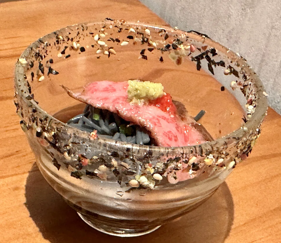 Cold somen in a soy sauce dipping sauce with a slice of wagyu tataki.