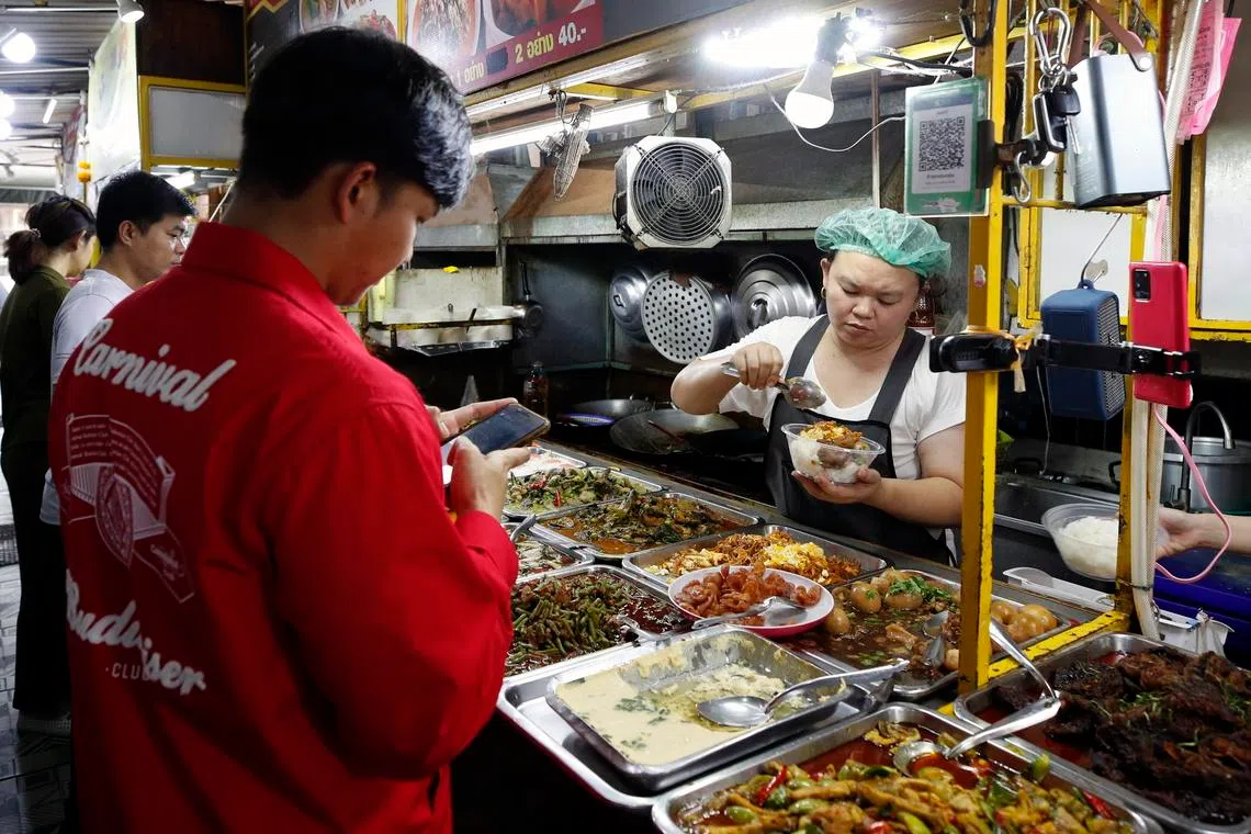 epa11692076 People buy street food at a market in Bangkok, Thailand, 30 October 2024. Thailand's gross domestic product (GDP) is forecasted to grow under three percent in 2024 as the economy is still recovering slowly and not showing a positive sign but should maintain a steady growth and is expected to expand more than five percent in 2025 driven by the influx foreign tourists, according to executive vice-president, company secretary, and executive director of Bangkok Bank, Kobsak Pootrakul.  EPA-EFE/RUNGROJ YONGRIT