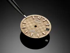 The dial of the new Ingenieur Automatic 35 features the hallmark grid motif of intersecting small lines and squares in a warm gold tone to match the case.