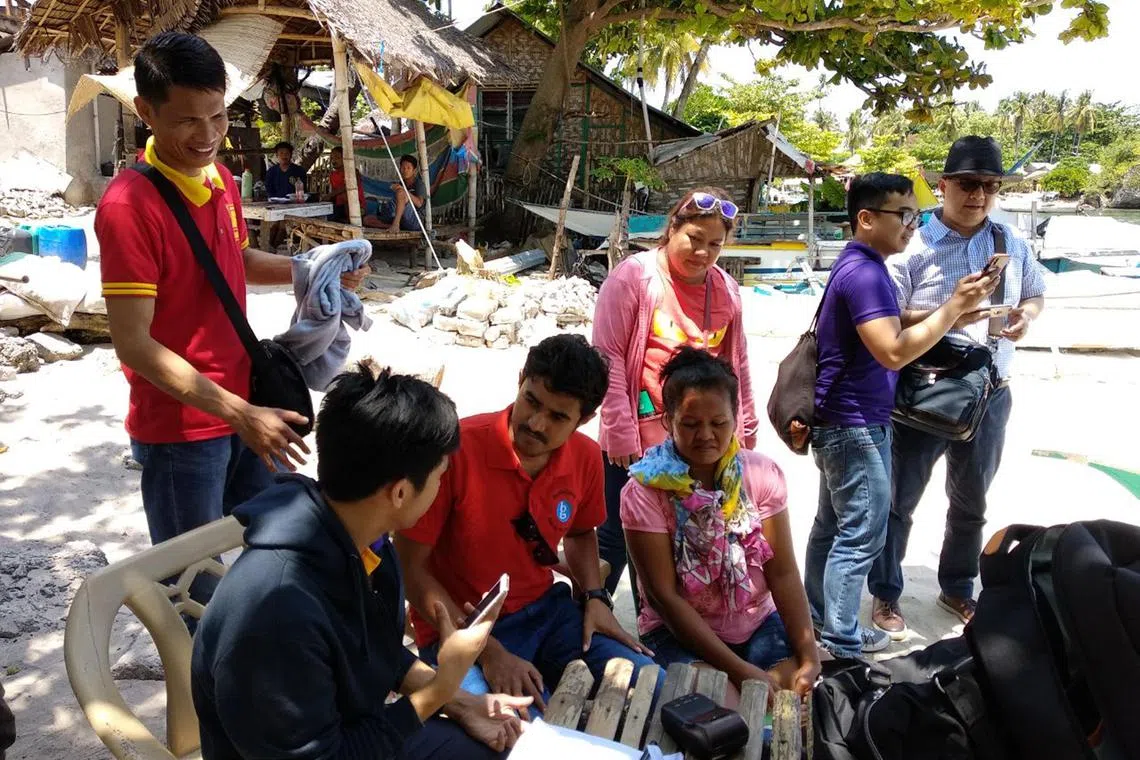 Villagers in the Philippines being introduced to Bank-Genie's financial services.