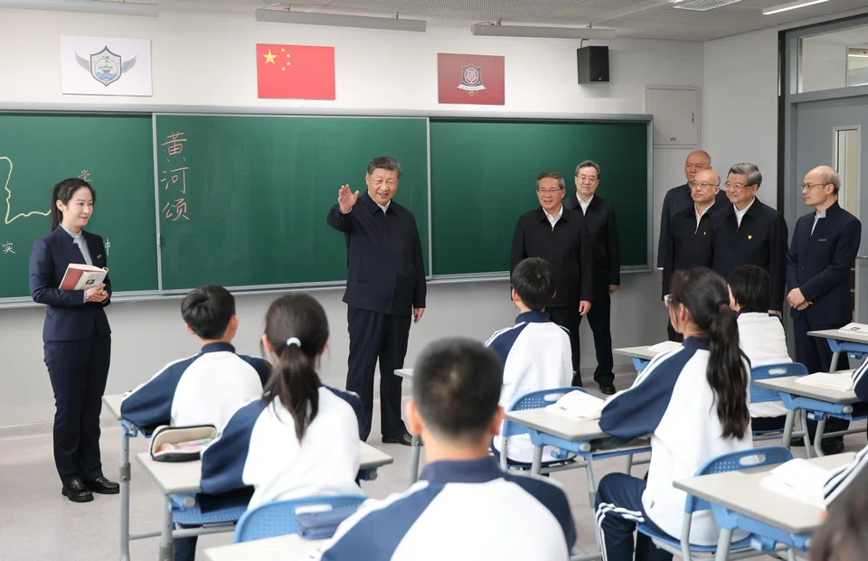 Chinese President Xi Jinping talks with students in a classroom at a high school, during an inspection tour of Xiongan New Area in Hebei province on Mar 23.
