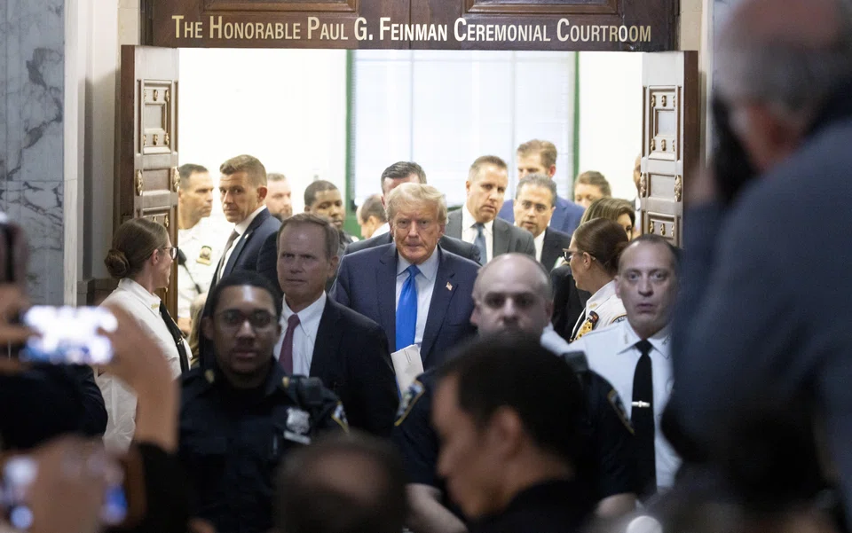 Former US President Donald J. Trump (centre) walks out of the courtroom after attending the first day of his civil fraud trial in New York, New York, Oct 2, 2023. 