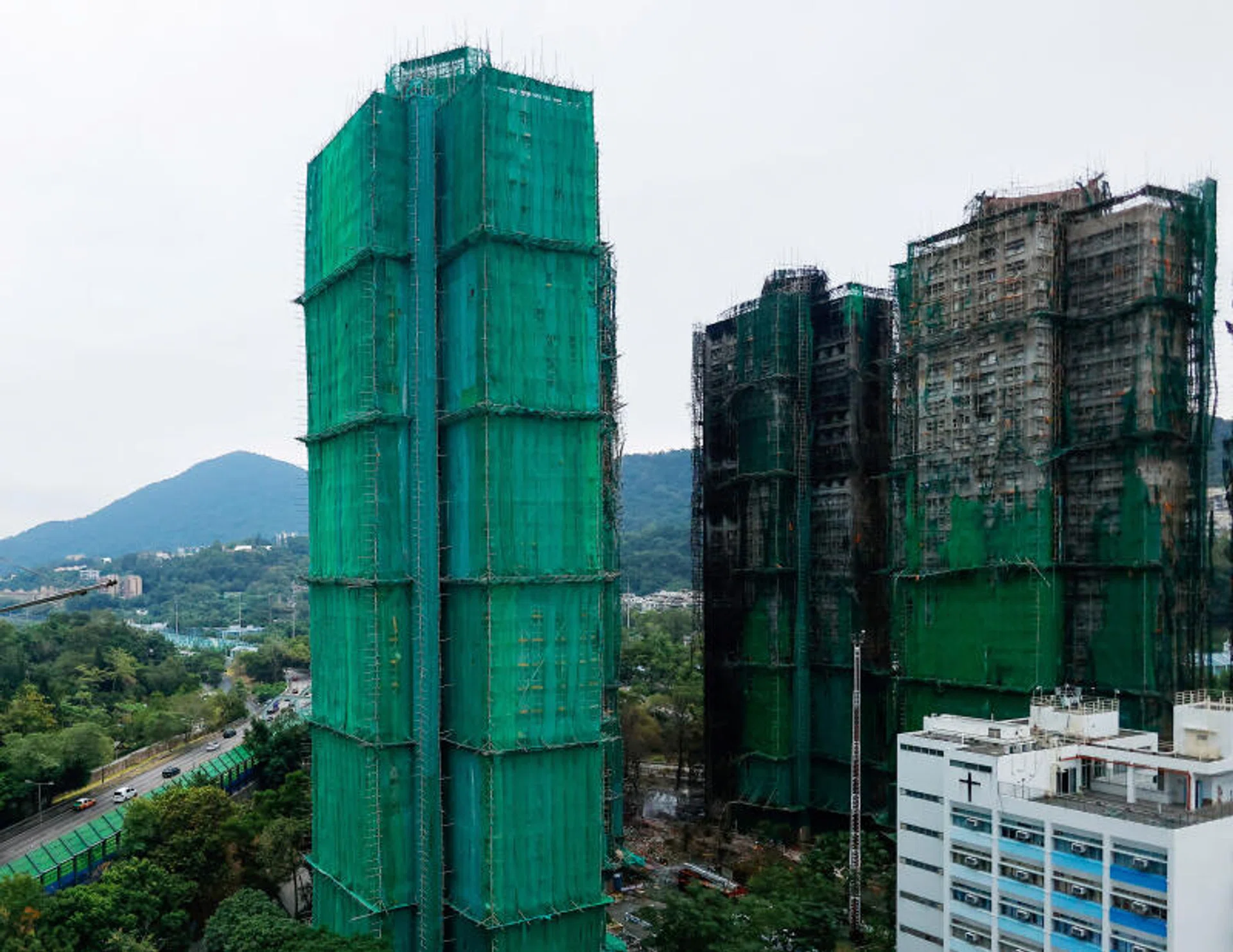 Hong Kong races to remove scaffolding nets blamed for fuelling deadly fire
