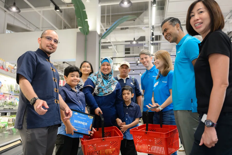 Accompanying a family during the guided shopping experience were Dr Syed Harun (first from left), Member of Parliament for Nee Soon GRC; Dwaipayan Sadhu, CEO of Trust Bank (second from right); and Denise Low (first from right), service delivery division director at MSF.