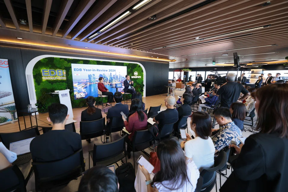 Jacqueline Poh (in red) and Png Cheong Boon, respectively the managing director and chairman of  the Singapore Economic Development Board, at the media briefing at the EDB's premises on Thursday.  