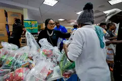 Democratic US Representative from Georgia Nikema Williams (left) helps distribute food aid bags during a free food distribution at the Young Family YMCA in Atlanta, Georgia, Nov 6, 2025. 
