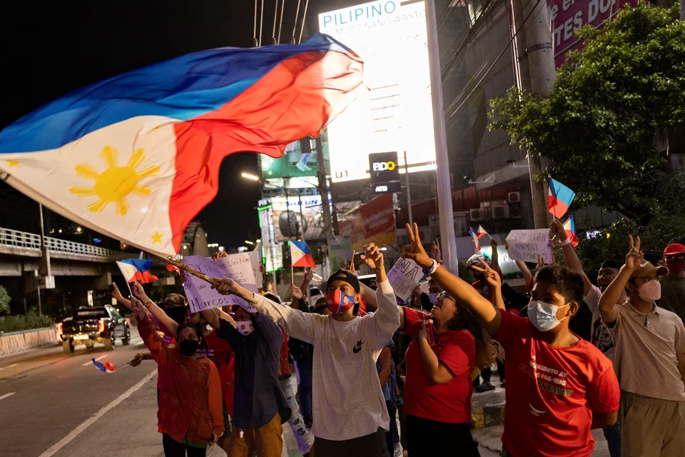 Supporters of presidential candidate Ferdinand "Bongbong" Marcos Jr celebrate outside his campaign headquarters in Mandaluyong City as partial results of the 2022 national elections showed him with a wide lead over rivals.  