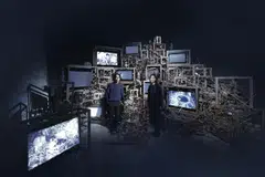 Artist Robert Zhao (left) and senior curator Haeju KIm against the forest-like structure in the Singapore Pavilion.