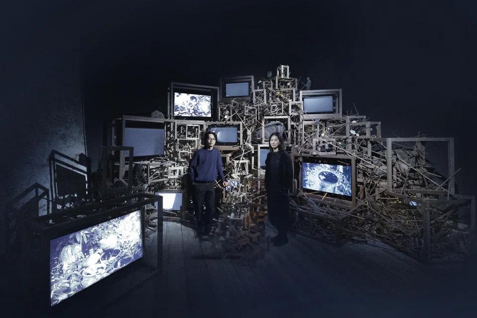 Artist Robert Zhao (left) and senior curator Haeju KIm against the forest-like structure in the Singapore Pavilion.