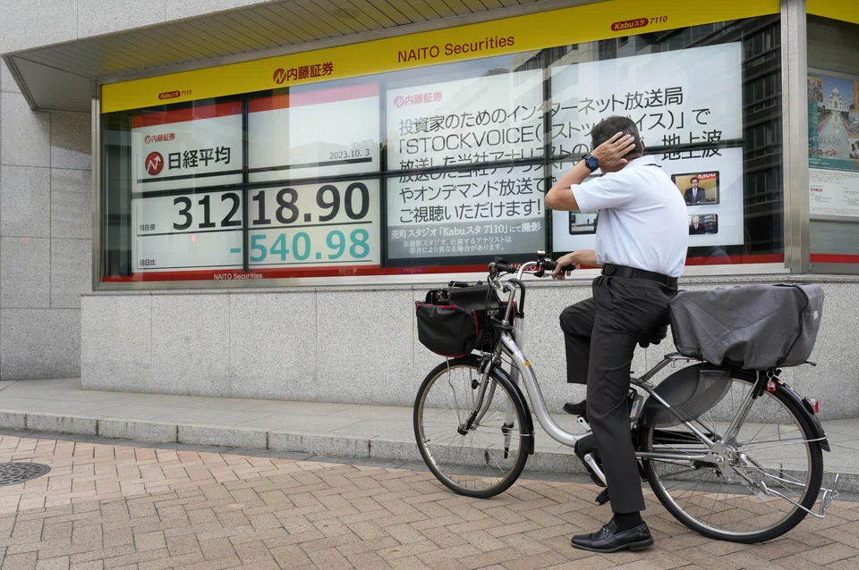 A man looking at a stock market indicator board in Tokyo, on Oct 3, as the yen continued its fall against the US dollar. 