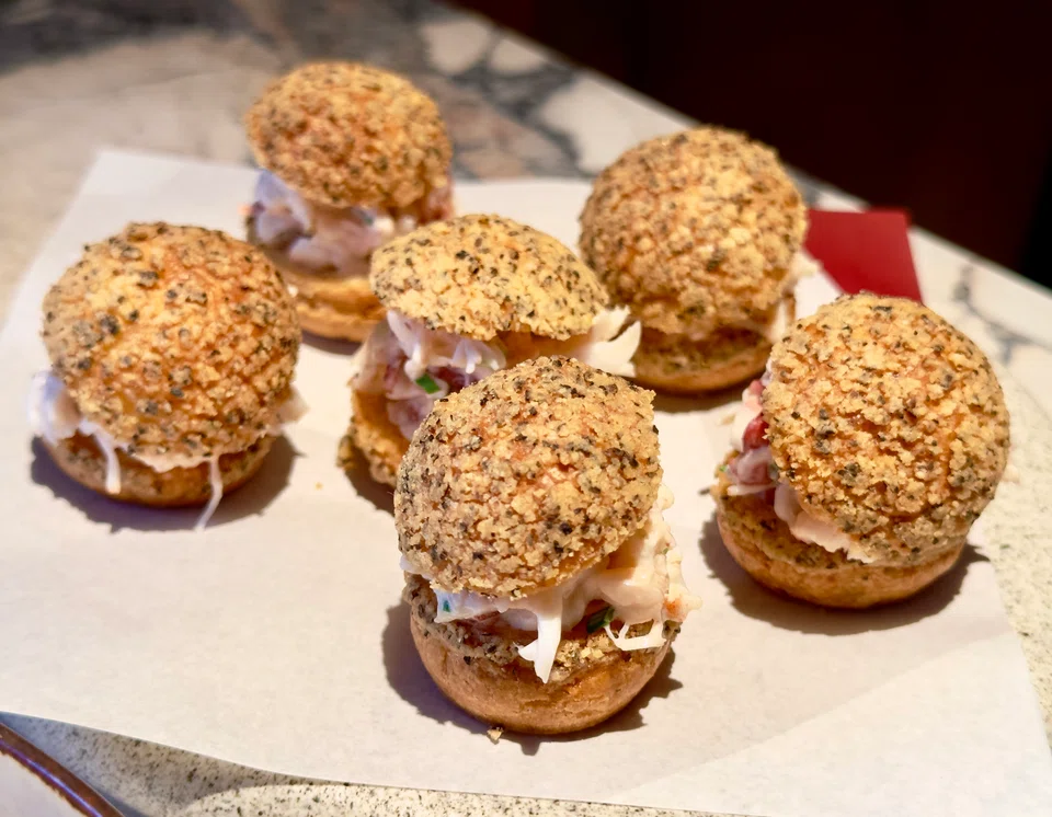 Canape-like black pepper choux puffs are filled with lobster salad.
