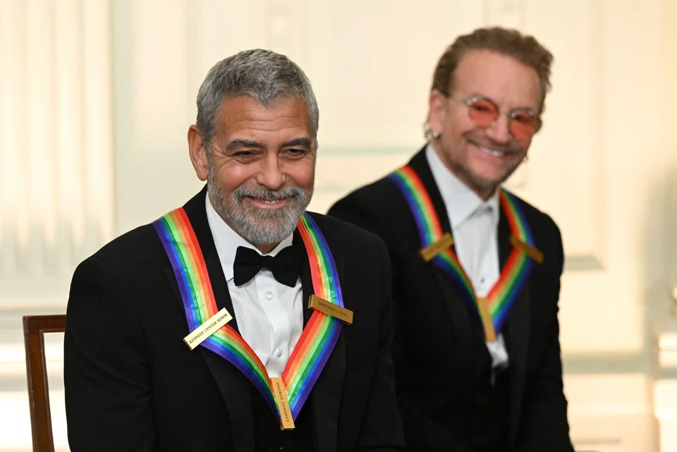 US actor George Clooney (left) and Bono of Irish band U2 attend a reception for the Kennedy Center Honorees in the East Room of the White House in Washington, DC, on Dec 4, 2022. 