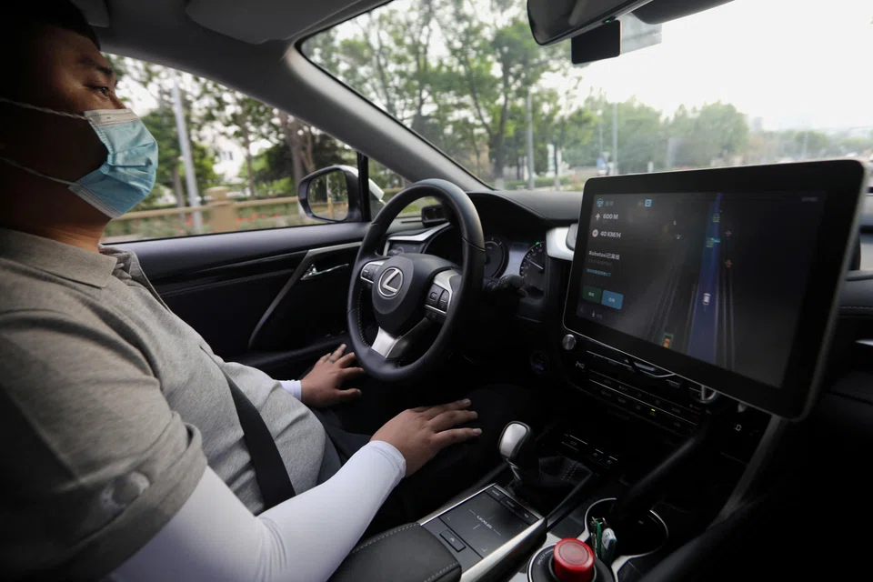 A safety driver monitors a Lexus vehicle equipped with Pony.ai's autonomous driving system as the car drives on a road during a test event, Beijing, China, May 13, 2021. Pony.ai plans to provide robotaxi commuting services for airport staff within Hong Kong International Airport before expanding into other urban areas in the city, the company said on Friday. 