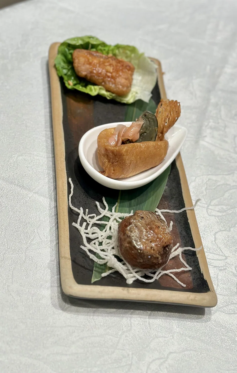 Combination platter of appetisers includes fried pork belly, century egg in beancurd wrapper and sauteed mushrooms.