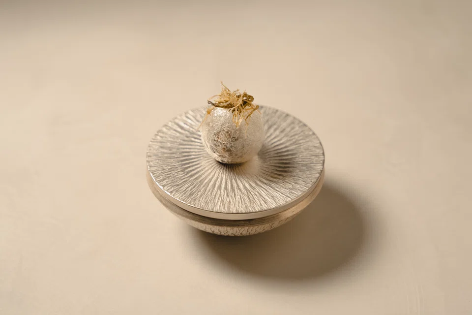 A crystal ball-like sphere is filled with oysters marinated in sheng yan sauce.