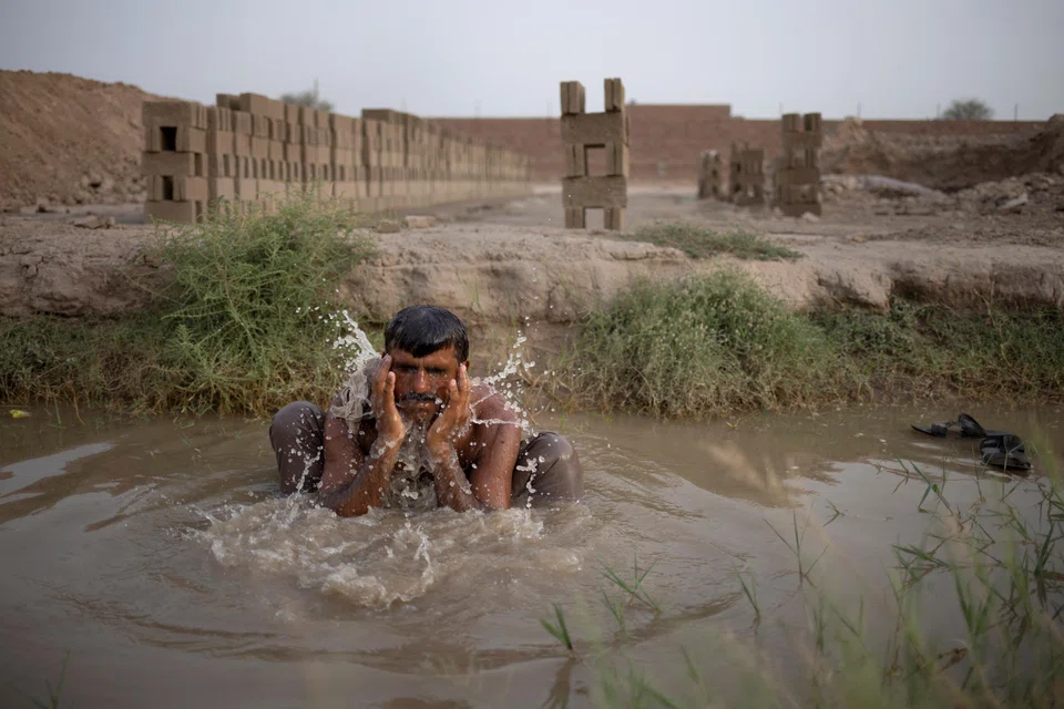 Allah Rakha, a 40-year-old brick moulder, cools off in a groundwater pool during a heatwave in Shujabad, Pakistan, June 4, 2025. 