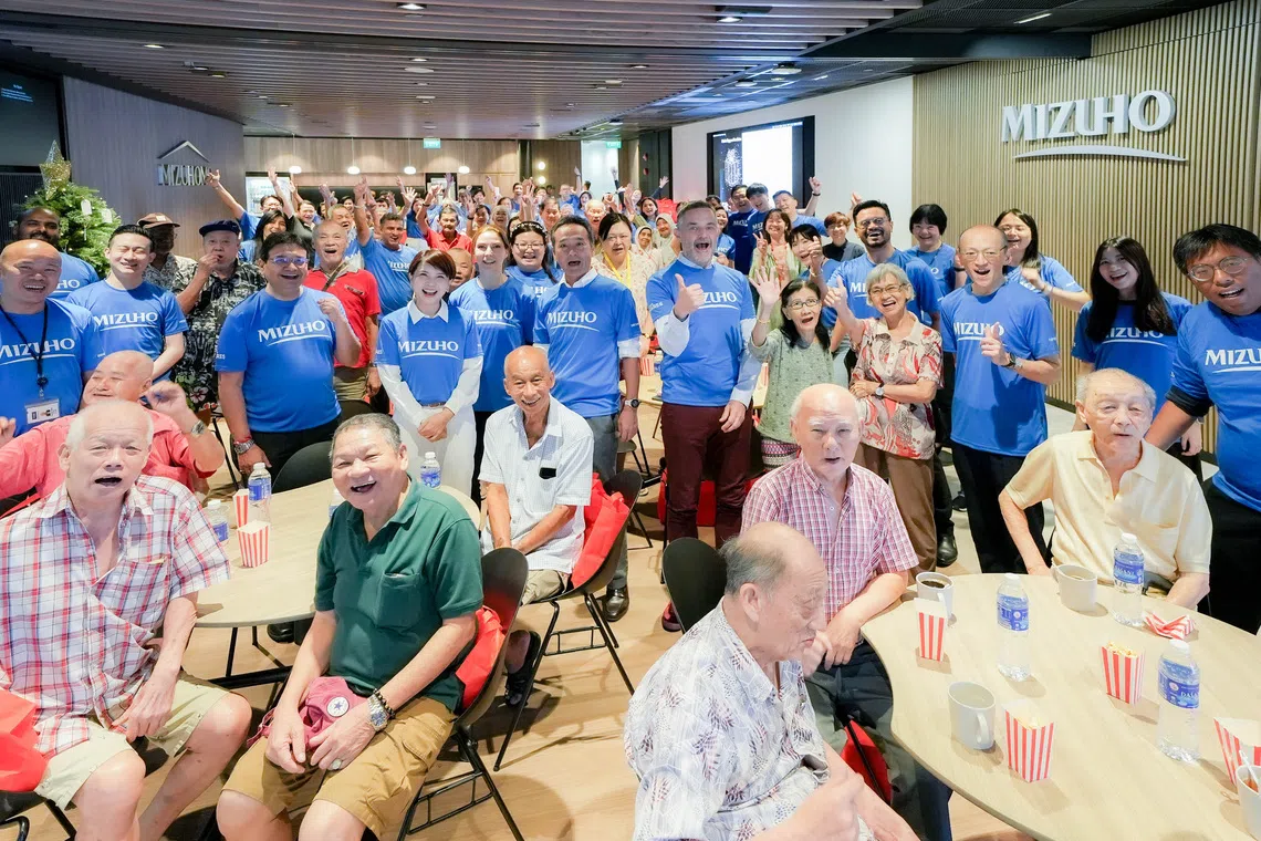 Mizuho Bank Singapore CEO Josephine Lok (fourth from left, in blue) at Mizuho Foundation's festive gathering with seniors from Awwa Senior Community Home.