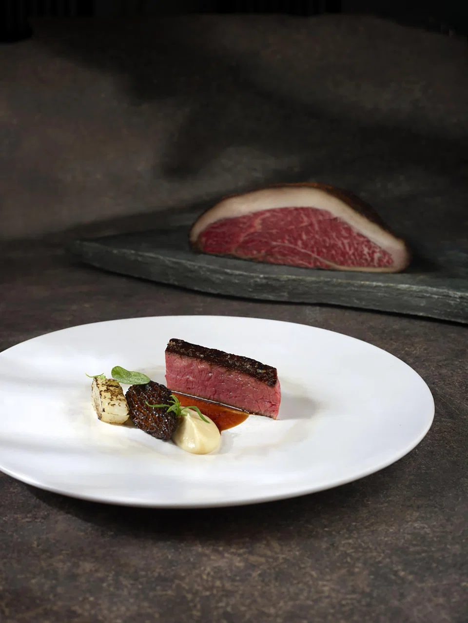 Wagyu rump cap is dry aged for 21 days and served with morel mushrooms stuffed with macadamia tofu.