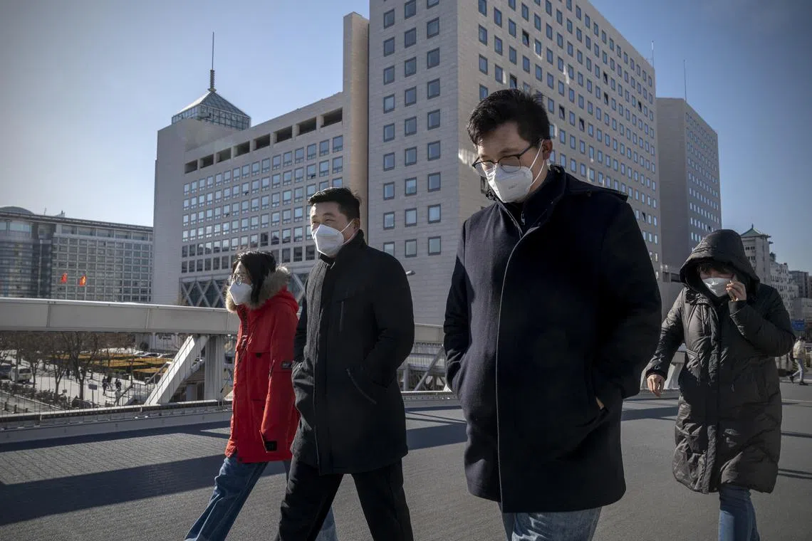 People walking past the Bank of China headquarters in Beijing, on Dec 22, 2022. In a recent interview, the central bank said it was relaxing the oversight of technology companies.   