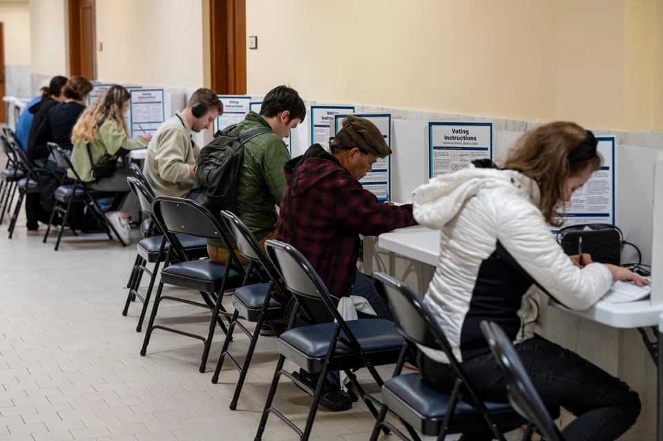 Voters mark their ballots at a polling location inside City Hall during early voting in San Francisco, California, Oct 31, 2024.