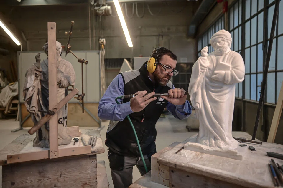 Sculptor Giovanni Calderino, 46, carves a Candoglia marble statue with a pneumatic hammer, as part of a project to replace ageing and damaged statues on Milan's gothic cathedral with perfect replicas.