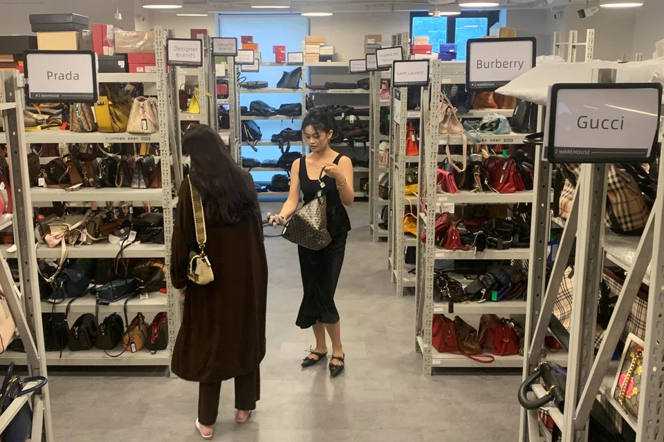 Customers look at bags displayed at ZZER, a second-hand luxury goods platform in Shanghai, China, Sept 9, 2022. 