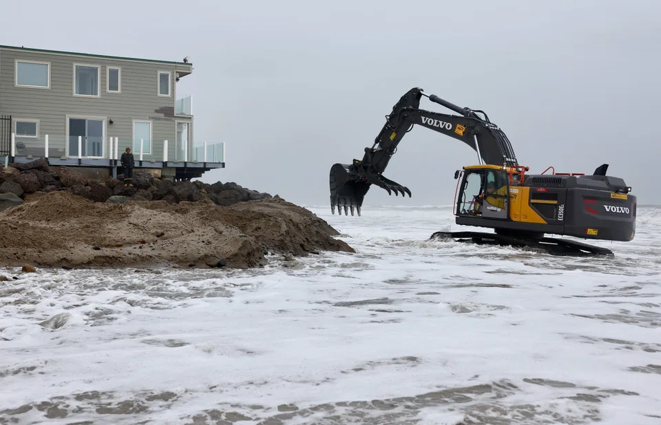 Workers shore up the Pacific Ocean coastline next to homes as a powerful long-duration atmospheric river storm, the second in less than a week, continues to impact Southern California near Malibu, California, Feb 5, 2024. 