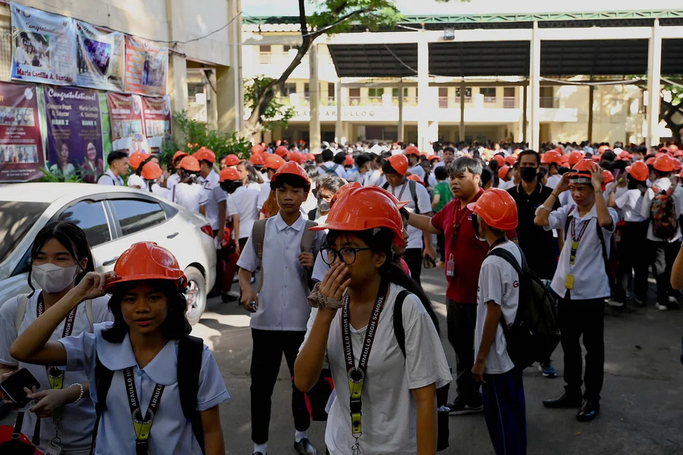 Students evacuate from their school building in Manila on Oct 13, 2023, after a magnitude 5.2 earthquake struck about 100 km south of the Philippine capital. 