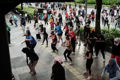 People taking part in a free Zumba dance workshop on a street during Car Free Day in Jakarta. 