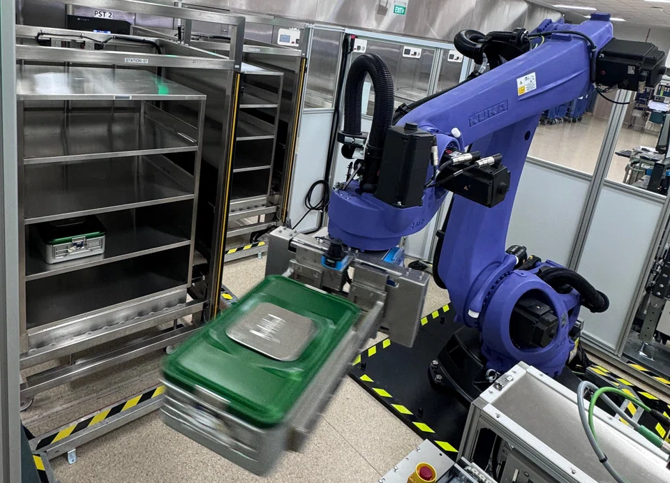 A three-arm robotic system, coupled with four Vertical Carousel Systems, automates the storage and retrieval of instrument sets.