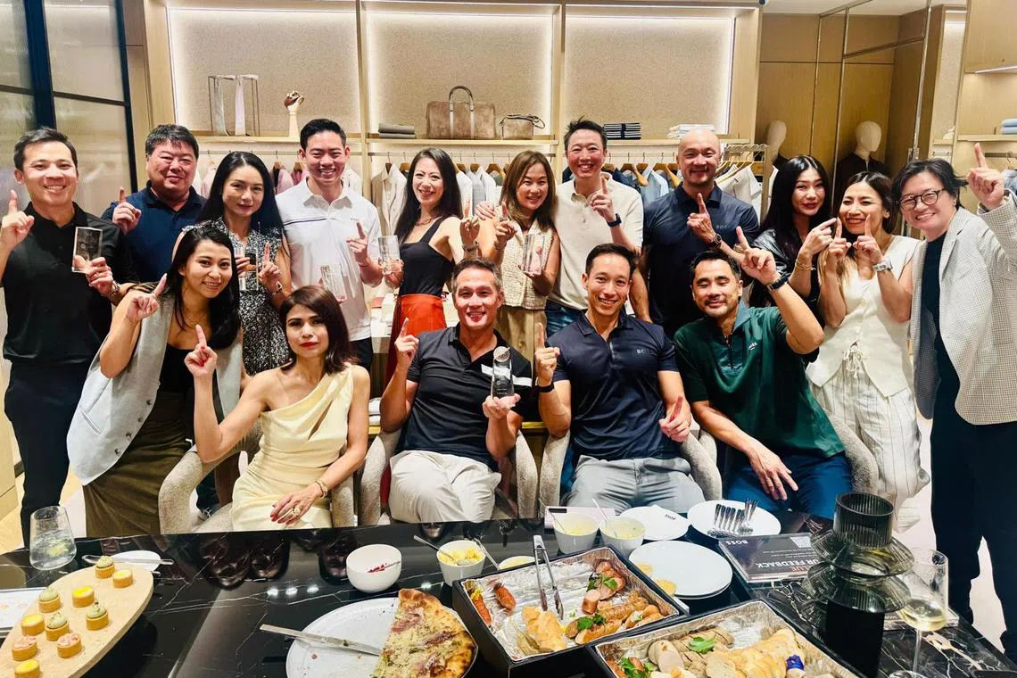 Team Boss golfers holding up their second runner-up trophies at a gathering to celebrate the BT Golf League. Seated are (from left) former captain Marilyn Lum, current vice-captain John Lim, current captain Andre Huber and managing director Steven Lam.