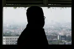 Asep Muizudin Muhamad Darmini, who was recently discharged from hospital after being treated for a respiratory illness caused by air pollution, looks on from his apartment in Jakarta as dense haze fills the skies. 