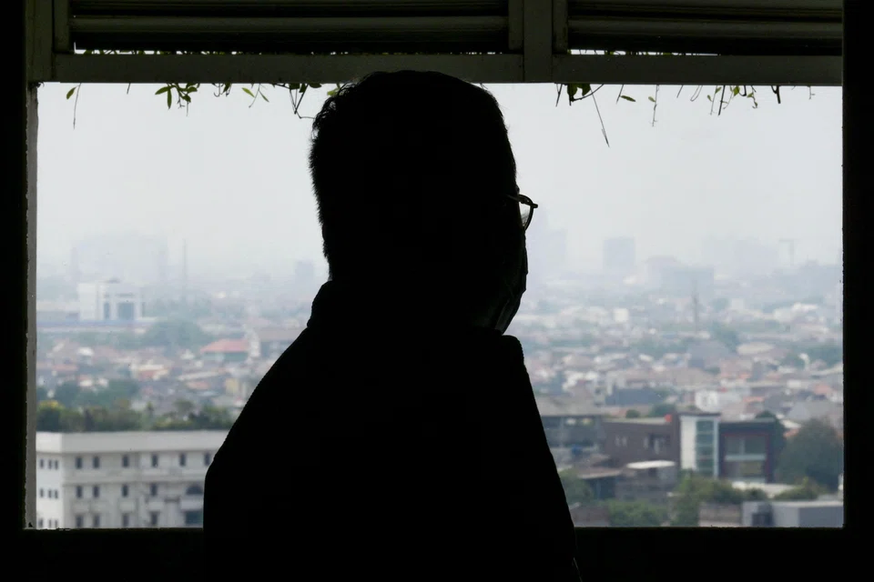 Asep Muizudin Muhamad Darmini, who was recently discharged from hospital after being treated for a respiratory illness caused by air pollution, looks on from his apartment in Jakarta as dense haze fills the skies. 
