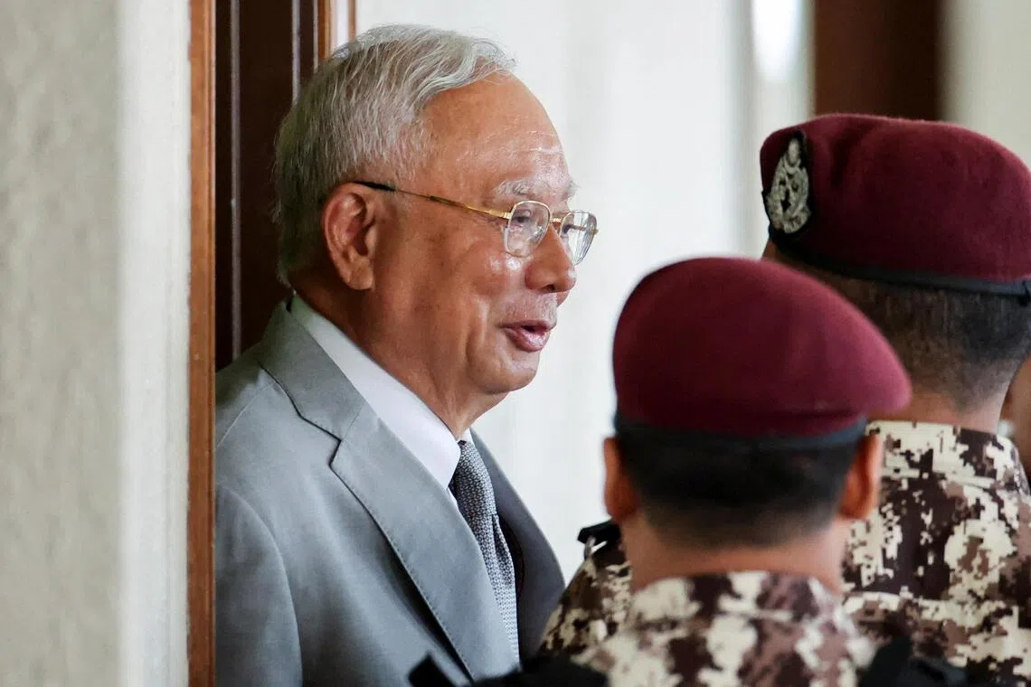 Malaysia's former Prime Minister Najib Razak, jailed for corruption in the multibillion-dollar 1MDB scandal, is escorted by prison guards at Kuala Lumpur Courts Complex, on the day he attends the verdict of his house arrest bid, at Kuala Lumpur, Malaysia December 22, 2025. REUTERS/ Hasnoor Hussain